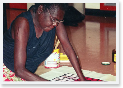 Mandjawuy family leader, teacher and school principal Nalwarri Ngurruwutthun painting on a large canvas