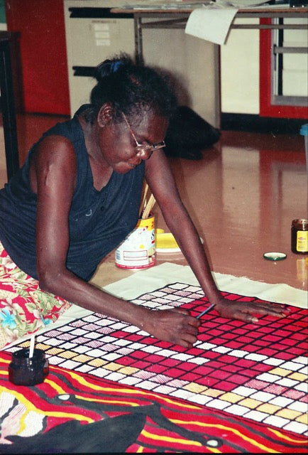 Mandjawuy family leader, teacher and school principal Nalwarri Ngurruwutthun painting on a large canvas