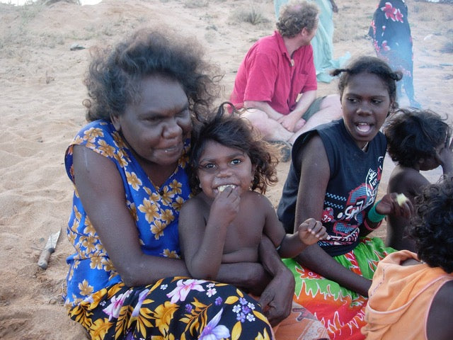 Indigenous family leader Nalwarri Ngurruwutthun cuddles Indigenous child on country at Mandjawuy in the Northern Territory