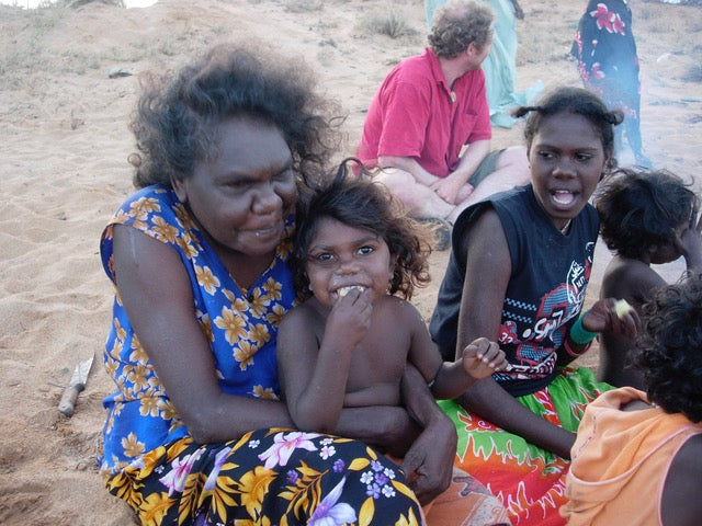 Indigenous family leader Nalwarri Ngurruwutthun cuddles Indigenous child on country at Mandjawuy in the Northern Territory 